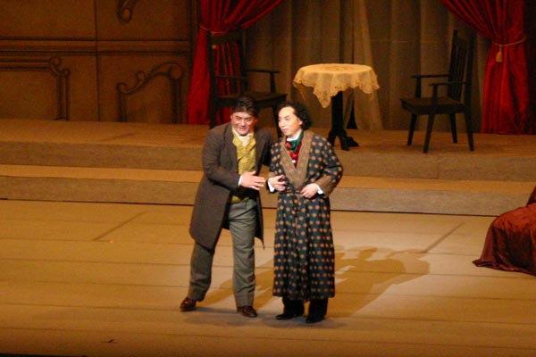 ひむかオペラ「喜歌劇 こうもり」 - なにやらうまい話でアイゼンシュタインを舞踏会に誘うファルケ博士(バリトン歌手 今村雅彦さん)。